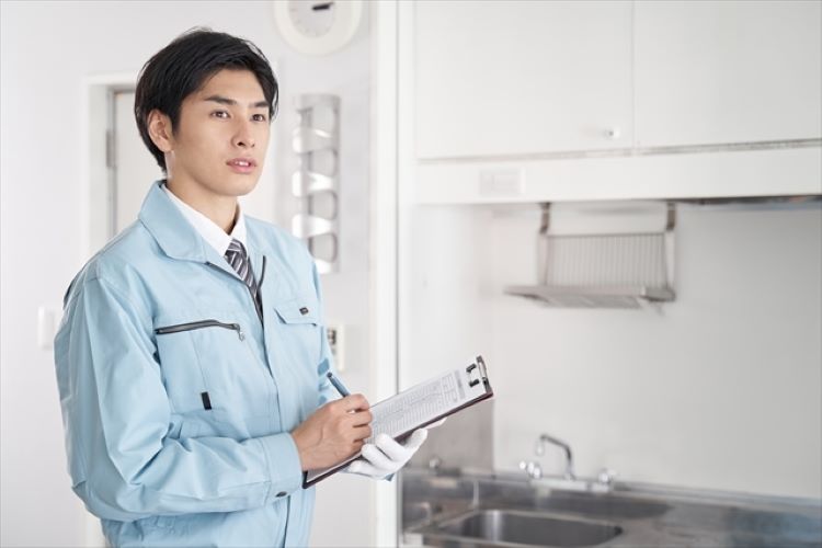 メモを取っている水道業者の写真