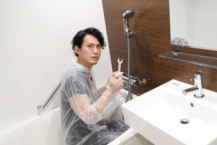 お風呂場で作業を行う男性の写真