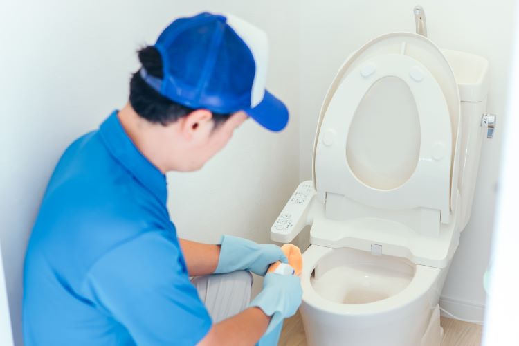 トイレを掃除する男性の写真